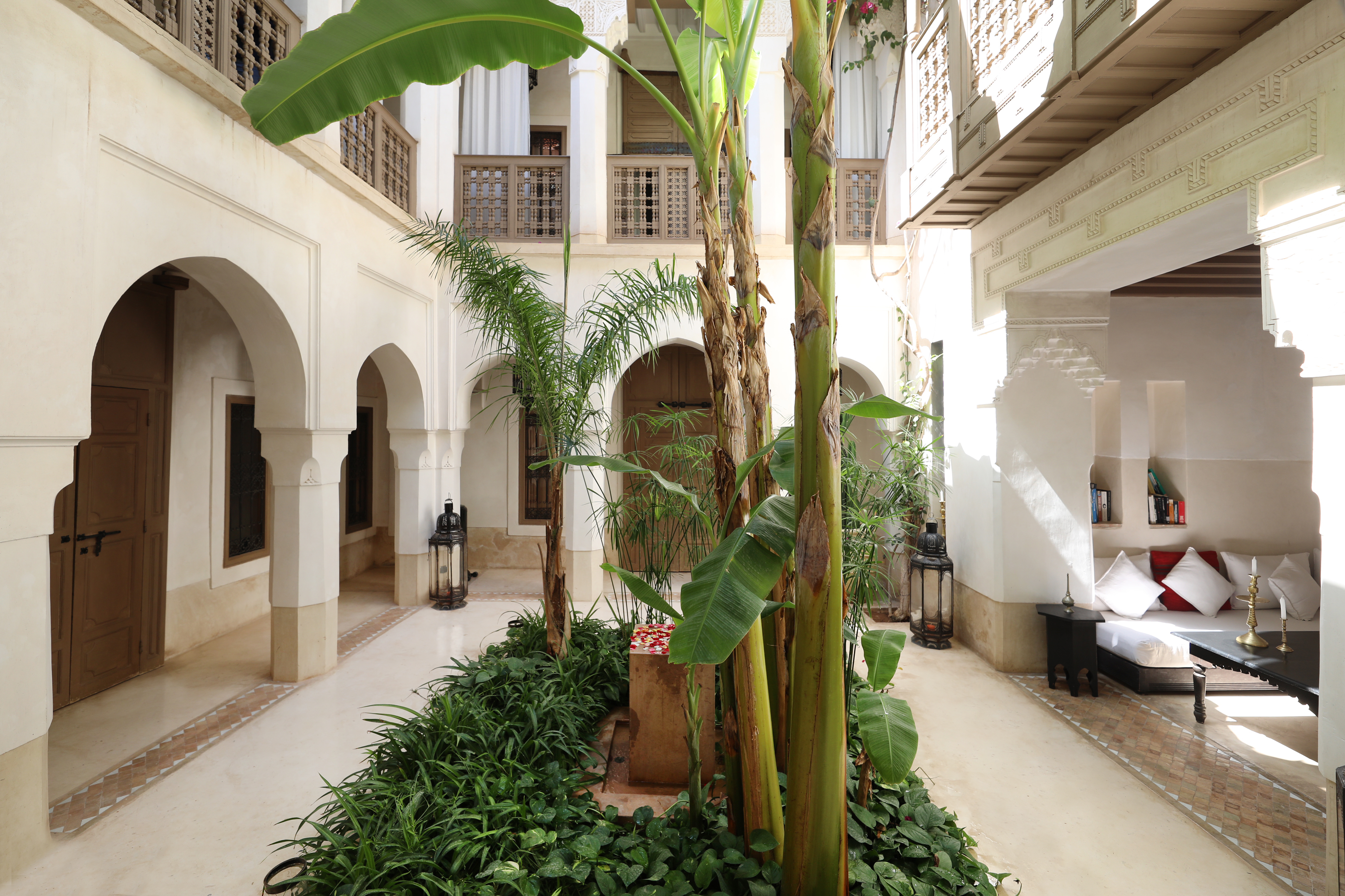 Les bananiers, les galeries blanches et le salon autour du patio du Dar Akal