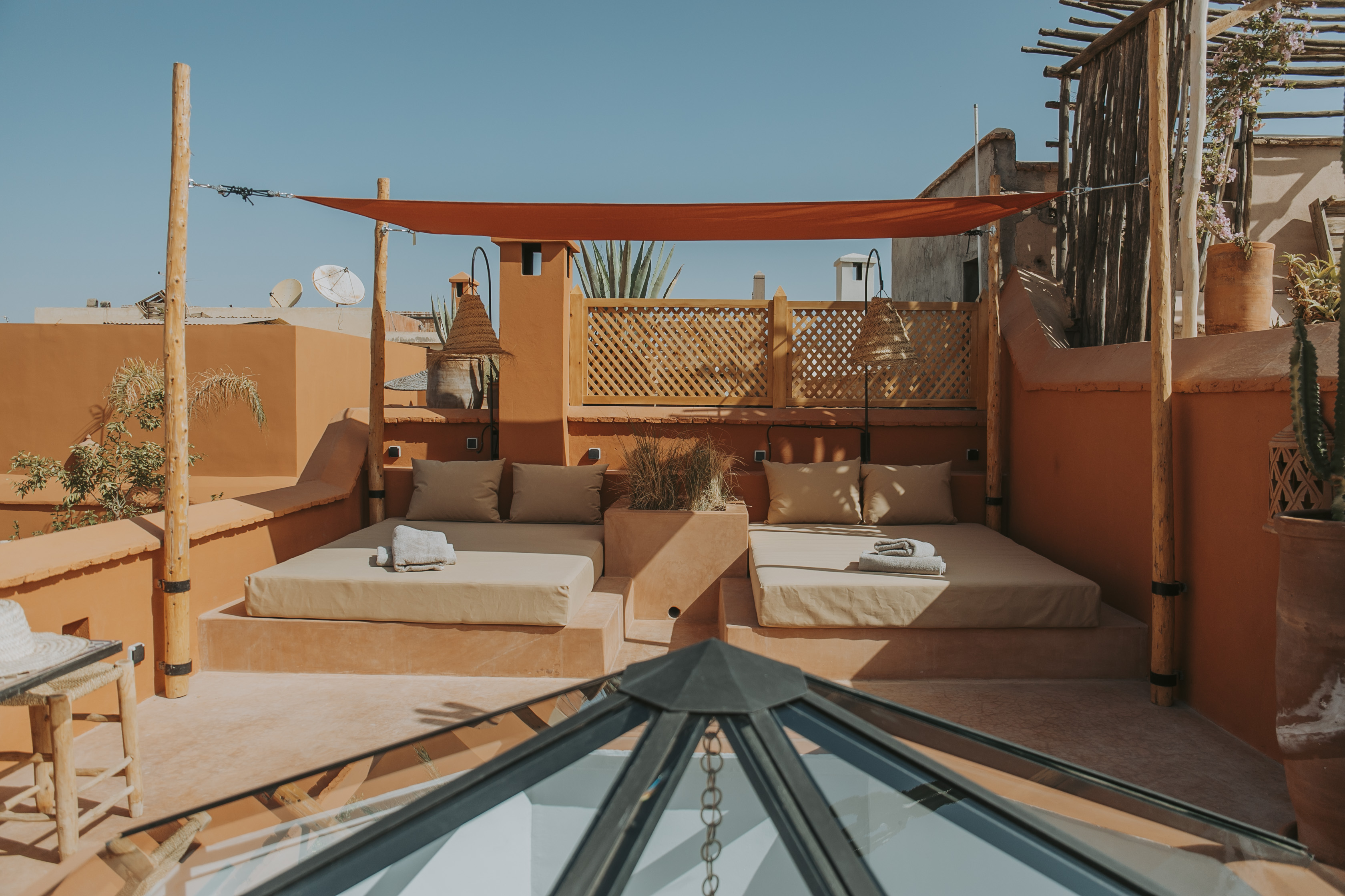 Deux banquettes ombragées sur la terrasse en terre cuite du Dar Akal